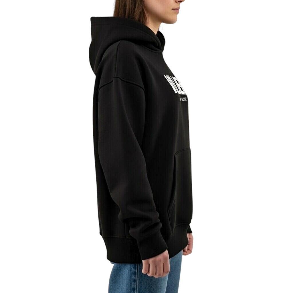 Damen Oversize Hoodie von VILLIERS MAISON SUISSE in Schwarz mit weissem Brustlogo, getragen von einem Model in seitlicher Ansicht.
