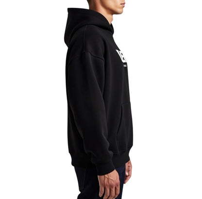 Herren Oversize Hoodie von VILLIERS MAISON SUISSE in Schwarz, getragen von einem Model in Rückenansicht mit sichtbarer Kapuze und lockerem Schnitt.