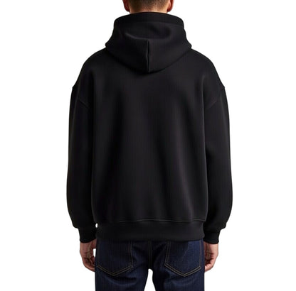 Herren Oversize Hoodie von VILLIERS MAISON SUISSE in Schwarz mit weissem Brustlogo, getragen von einem Model in seitlicher Ansicht.