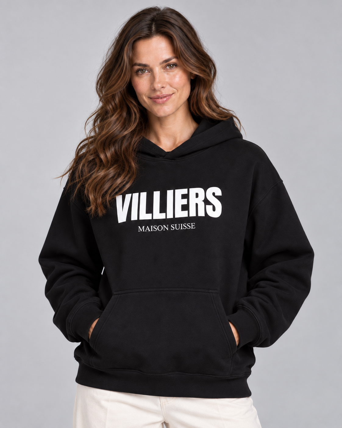 Frau trägt schwarzen Oversize Hoodie von Villiers Maison Suisse mit weissem Brustprint, Oberkörper von vorne
