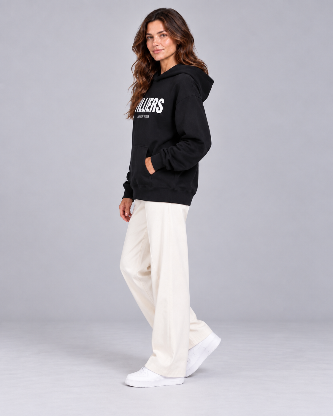 Frau trägt schwarzen Oversize Hoodie von Villiers Maison Suisse in der Seitenansicht
