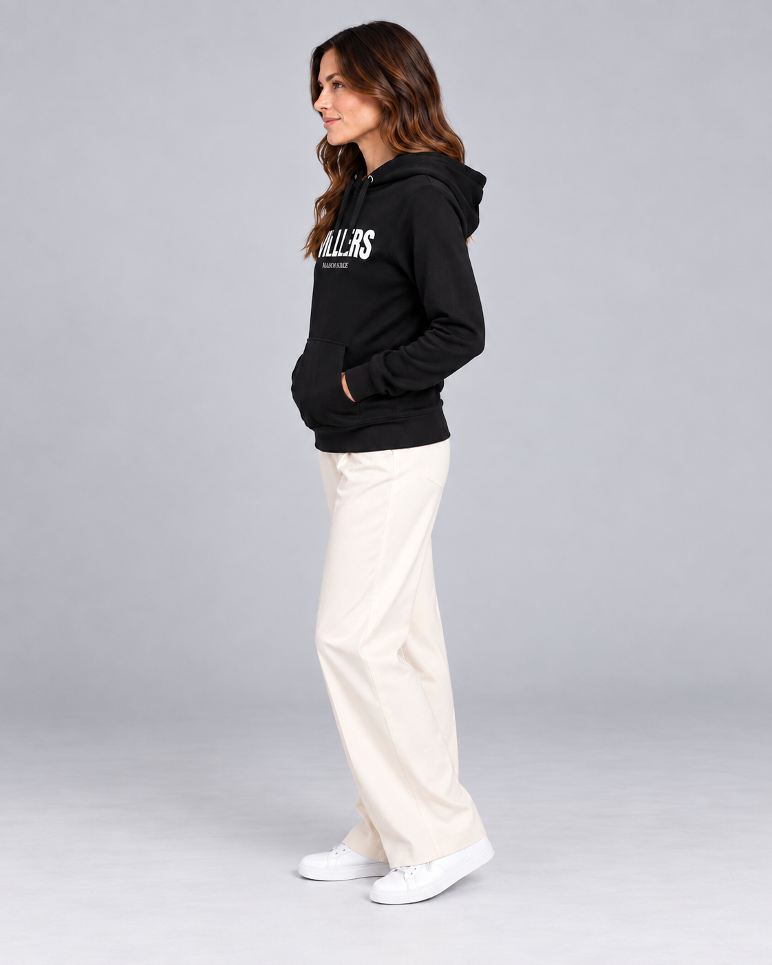 Frau trägt schwarzen Premium Hoodie von Villiers Maison Suisse in der Seitenansicht
