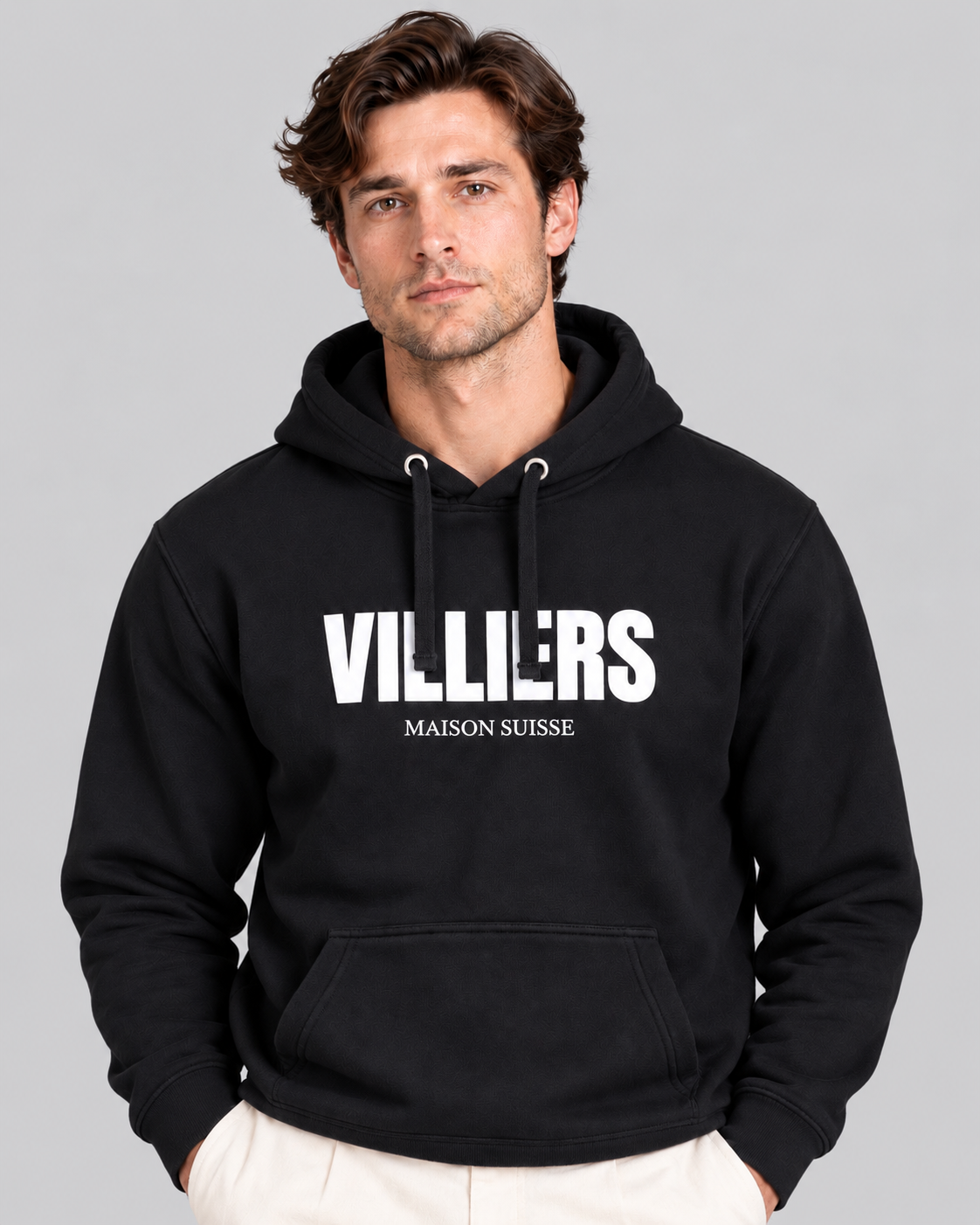 Mann trägt schwarzen Premium Hoodie von Villiers Maison Suisse mit weissem Brustprint, Oberkörper von vorne
