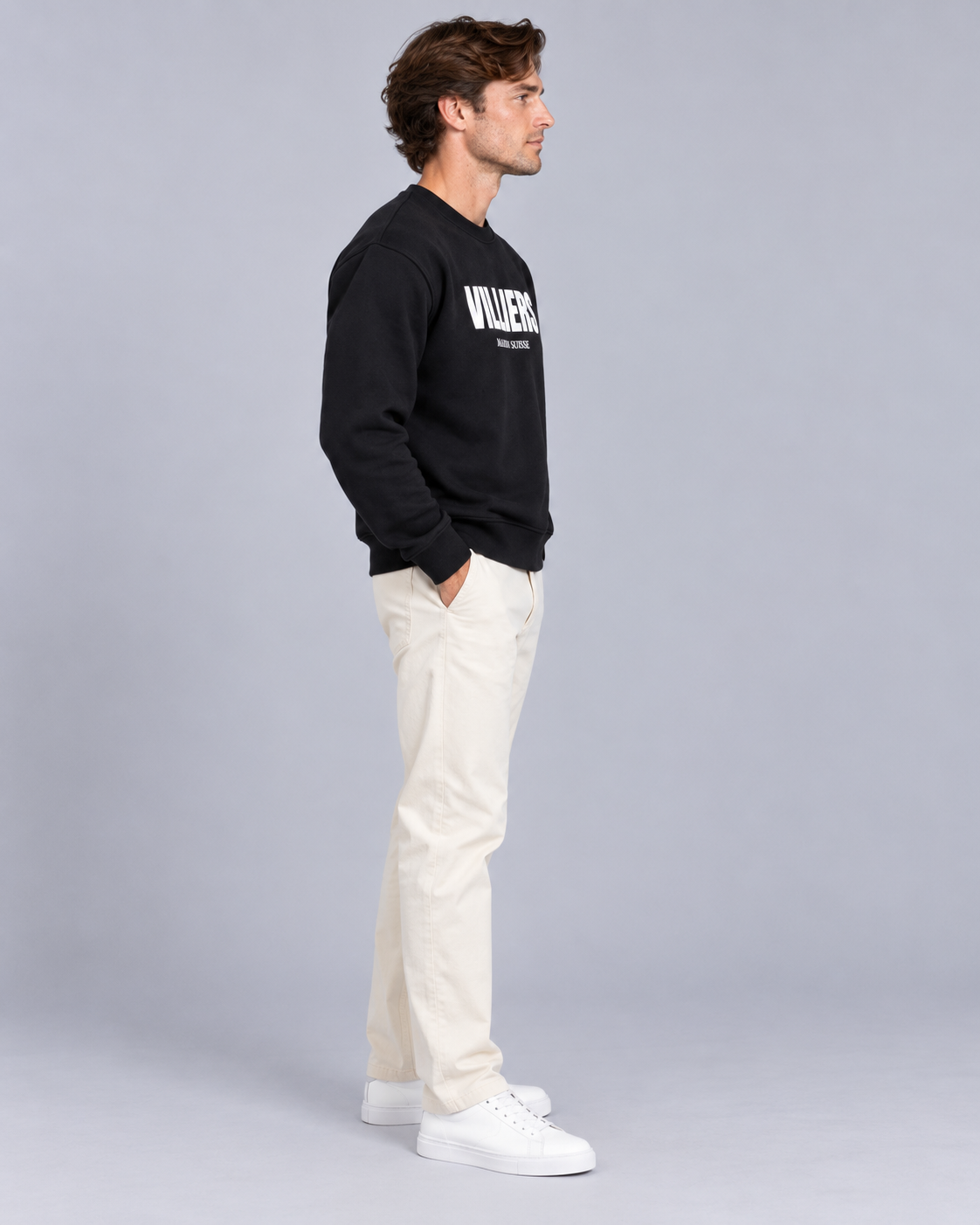 Mann trägt schwarzes Sweatshirt von Villiers Maison Suisse in der Seitenansicht
